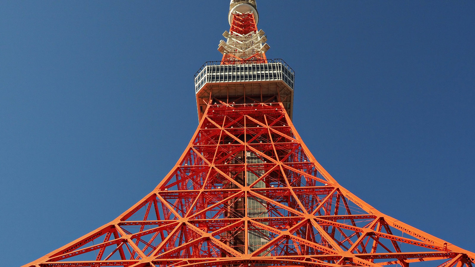 Tokyo Tower's red-and-white lattice steel structure rising against a clear blue sky