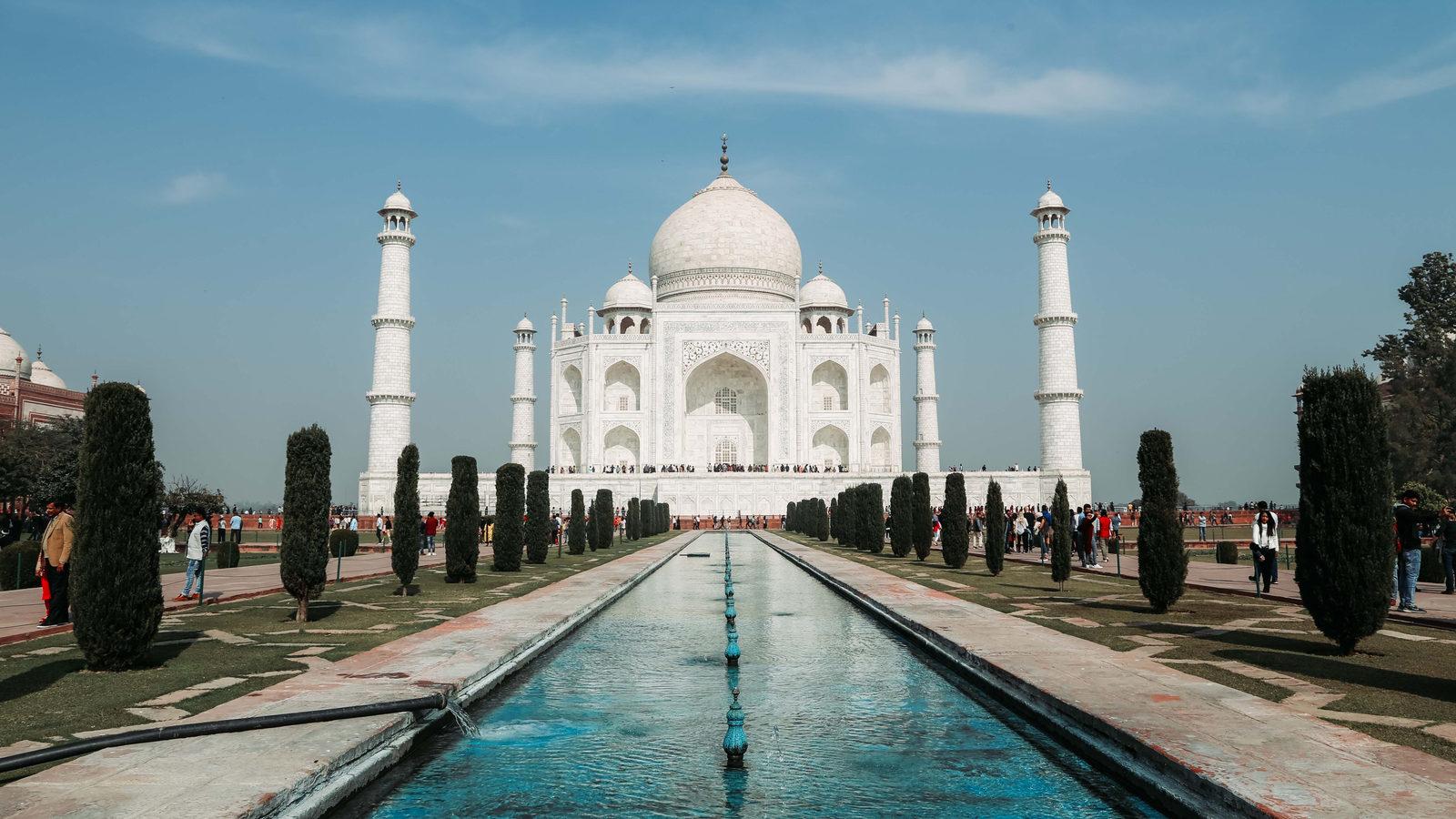 The Taj Mahal in Agra, India, reflected in its long rectangular pool under a clear blue sky